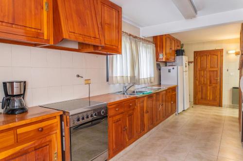 a kitchen with wooden cabinets and a stove top oven at Casa Vintage in San Carlos de Bariloche