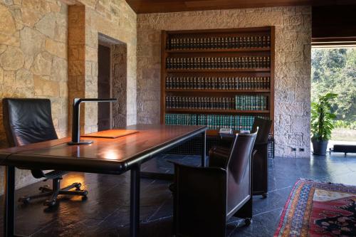an office with a wooden table and chairs and a book shelf at Casakubrick mansión in Castelltersol