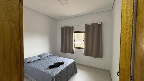 ein Schlafzimmer mit einem Bett und einem Fenster in der Unterkunft Hospedagem Café São Thomé in São Thomé das Letras