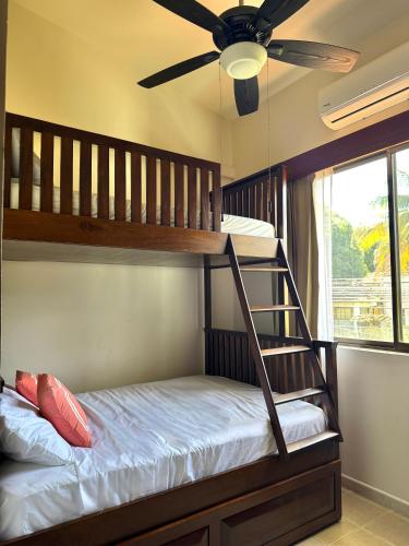 a bedroom with a bunk bed with a ceiling fan at Coastal Comfort Spacious Second-Floor Getaway in Coco