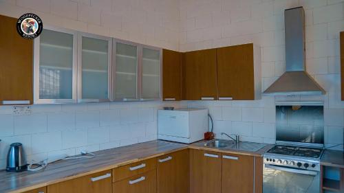 a kitchen with wooden cabinets and a stove top oven at Woodpecker Resort Hotel in Bathurst