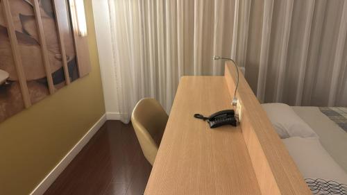 a wooden table with a phone on top of it at Flat MERCURE Premiu Executive in Manaus