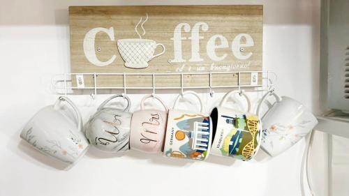 a shelf with cups and a coffee sign on a wall at Eco's Place GenTri - Family Bungalow in General Trias