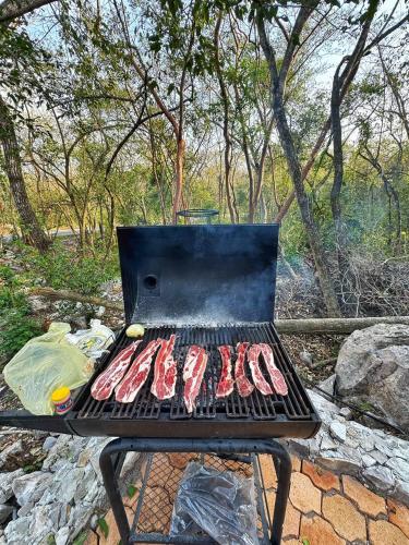 a grill with a bunch of meat on it at Glamping El Cielo Adventures in Gómez Farías