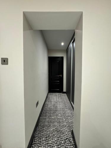 an empty hallway with a black door and a tile floor at Luxury 3bed Hot Tub and sauna facilities amazing location in Birmingham