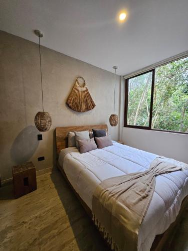 a bedroom with a large bed and a window at Luxe Tulum Jacuzzi in Tulum