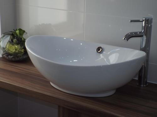 a white bowl sink sitting on top of a wooden counter at Tyndale B&B Torquay in Torquay