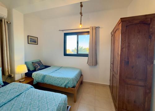 a bedroom with two twin beds and a window at Lighthouse Residence in Dahab