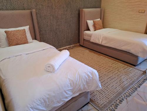 a room with two twin beds with white sheets at Azur appartement essaouira in Essaouira