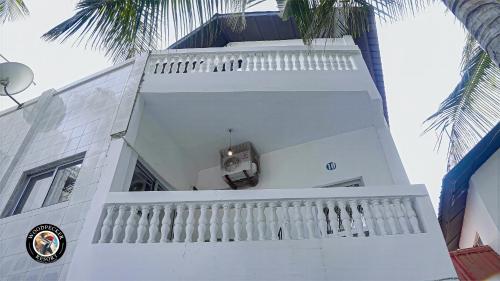 a white building with a balcony and palm trees at Woodpecker Resort Hotel in Bathurst