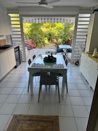 a kitchen with a table in the middle of a room at Ti paradis créole - Sainte-Anne in Plaisance