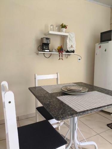 a kitchen with a table and two white chairs at Espaço Vendrame in Criciúma