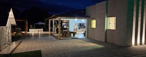 a patio of a house at night with a table at Chalé Estância Morada Nova in Coração de Jesus