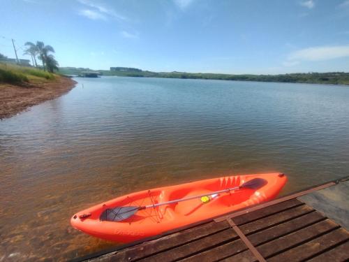 an orange kayak sitting on a dock on a river at Casa de Charme Camargos in São João del Rei