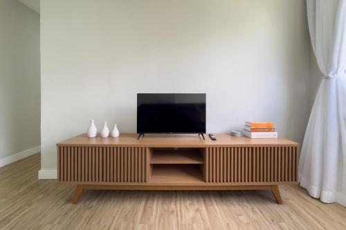 a television on a wooden entertainment center in a living room at Ap Expo SP e Zoológico in Sao Paulo