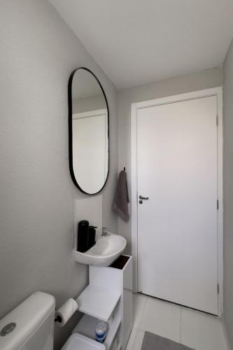 a white bathroom with a sink and a mirror at Ap Expo SP e Zoológico in Sao Paulo