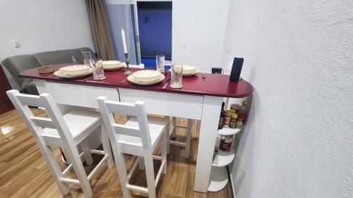 einen Tisch mit vier Stühlen und einer roten Arbeitsplatte in der Unterkunft Estancia Chon Cortes in Cupilco
