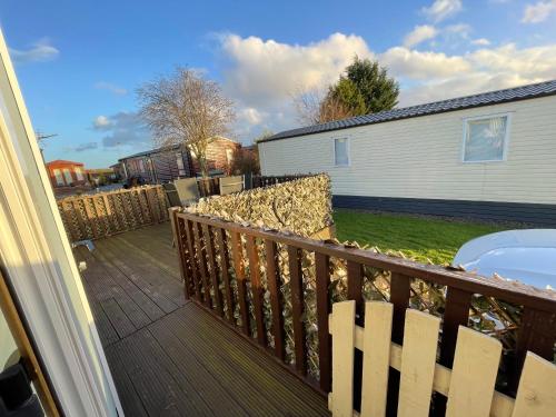 a balcony of a house with a fence at 7 Rannoch Row, lovely holiday static caravan for dogs & their owners. in Forfar