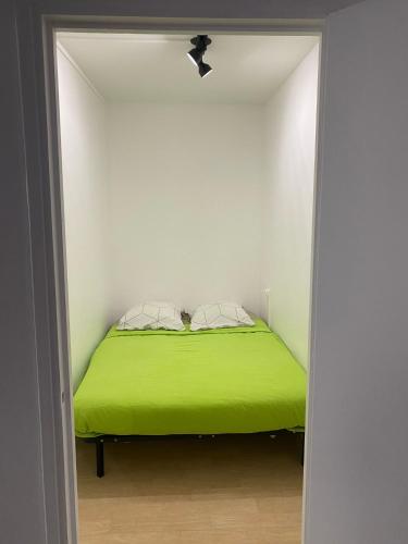 - une chambre blanche avec un lit vert dans l'établissement The Cosy studio Aubervilliers - Metro 12, à Aubervilliers