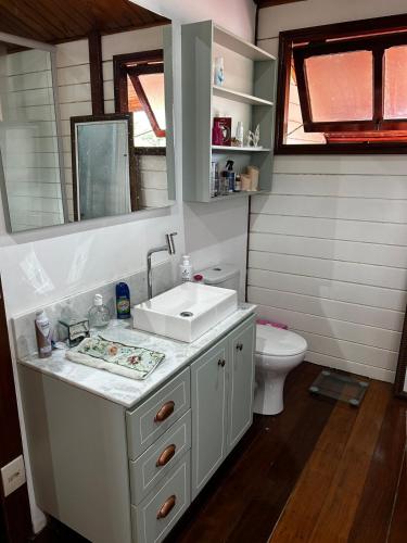 a bathroom with a sink and a toilet at Casa Raízes - Atibaia in Atibaia