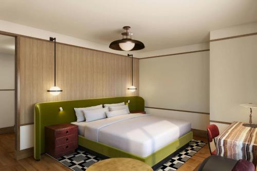 a bedroom with a bed with a green headboard at The Tallison Hotel, a Tribute Portfolio Hotel in Carmel