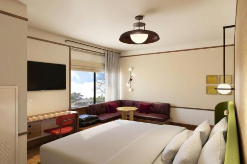 a hotel room with a bed and a couch at The Tallison Hotel, a Tribute Portfolio Hotel in Carmel