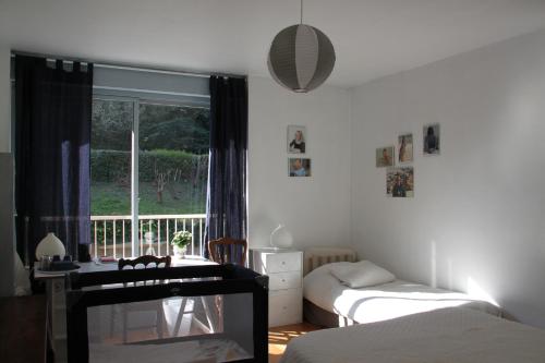 a bedroom with two beds and a window with a balcony at Les Hauts de Perrache in Sainte-Foy-lès-Lyon