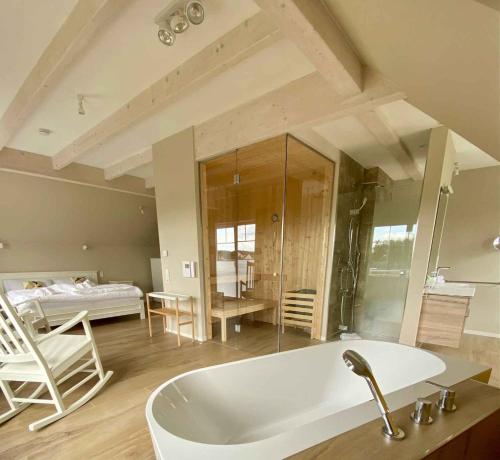 a bathroom with a tub and a bedroom with a bed at Holiday home in Altwarp 50009 in Altwarp