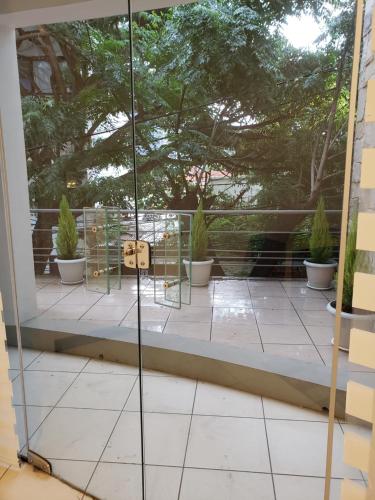 a glass door on a balcony with potted plants at Siéntete como en tu casa in Tarija