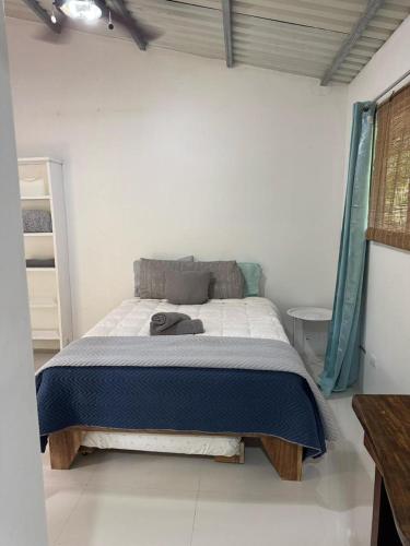 a bedroom with a bed in a white room at Tiny jungle house, few minutes from the beach in Cocles