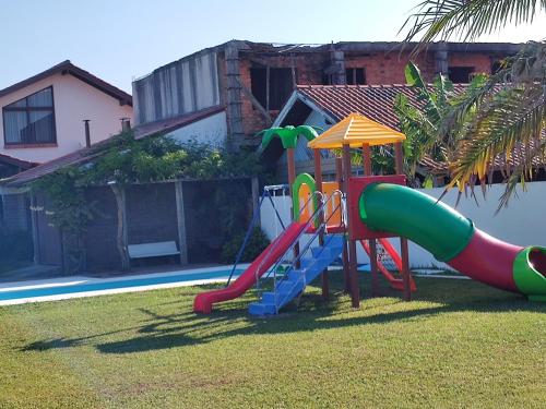 a playground with a slide in a yard at Casarão temporada verão - Propriedade do Hotel Matos in Capão da Canoa