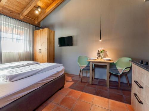 ピーゼンドルフにあるTauern Suites Mitterwirt TOP 121のベッドとテーブルと椅子のある寝室