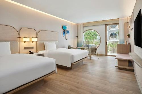 a hotel room with two beds and a television at Veranda Resort Phuket, Autograph Collection in Panwa Beach