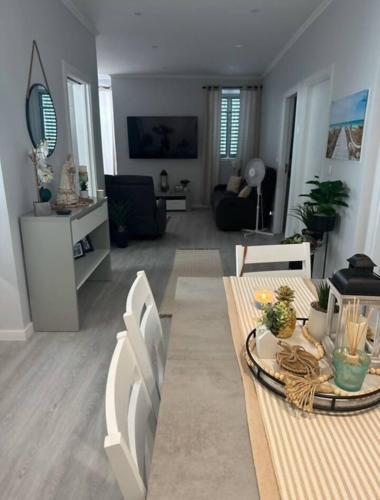 a living room with a table and a couch at Maré Alta - Scenic Seaside Stay with outdoor deck in Vila Franca do Campo