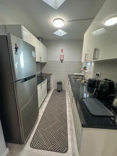 a large kitchen with a stainless steel refrigerator at Maré Alta - Scenic Seaside Stay with outdoor deck in Vila Franca do Campo