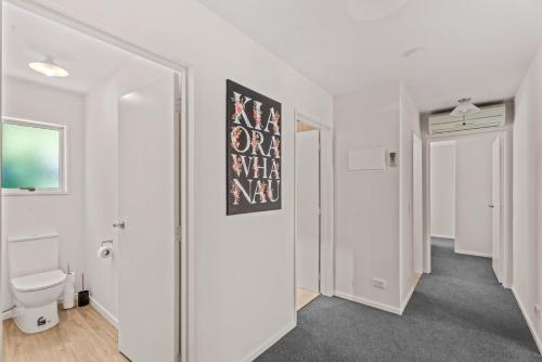 a white room with a toilet and a mirror at Mountain View Paradise 3 Bedroom House Lake Views in Queenstown