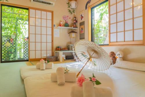 a room with a bed with a fan and windows at 東京吉久花園旅館 in Tokyo