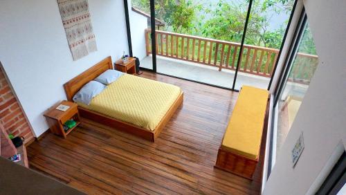 a small bedroom with a bed and a balcony at The Cloud Forest Retreat in Pelagallo