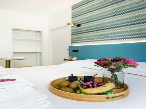 - un plateau de fruits sur un lit avec un vase de fleurs dans l'établissement Cosy Apartment - Parc des expositions Tour Eiffel 1, à Paris