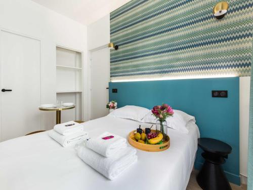 - un lit avec un bol de fruits et une corbeille de fleurs dans l'établissement Cosy Apartment - Parc des expositions Tour Eiffel 1, à Paris