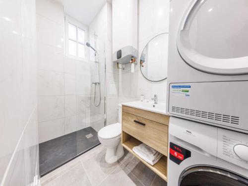une salle de bain blanche avec des toilettes et un lavabo dans l'établissement Cosy apartment - 2BR 5P - Jardin du Luxembourg, à Paris