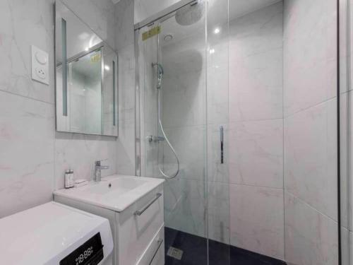 une salle de bain blanche avec une douche et un lavabo dans l'établissement Cosy apartment - 1BR 4P - Jardin du Luxembourg, à Paris