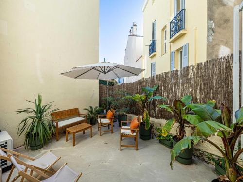 une terrasse avec des chaises, un parasol et des plantes dans l'établissement Superb 1BR 2p in the heart of Cannes - Balcony, à Cannes