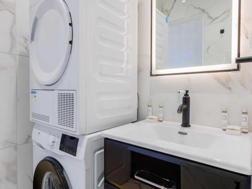 une salle de bain avec une machine à laver et un lavabo dans l'établissement Cosy Apartment Le Bon Marche, à Paris
