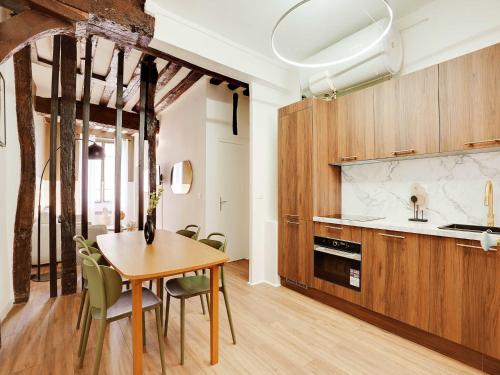 une cuisine et une salle à manger avec une table et des chaises dans l'établissement Eclectic apartment - 2BR 6P - Jardin du Luxembourg, à Paris