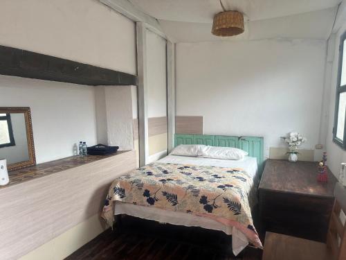 a bedroom with a bed and a mirror at Hostal Casa La Merced in Antigua Guatemala