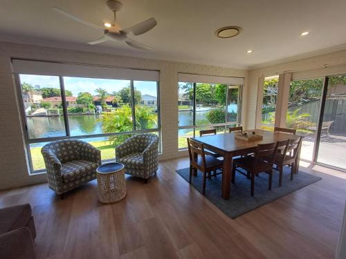 a living room with a dining room table and chairs at Castaway on King George in Forster