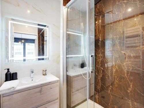 une salle de bain avec une douche, un lavabo et un miroir dans l'établissement Duplex with terrace in Levallois, à Levallois-Perret
