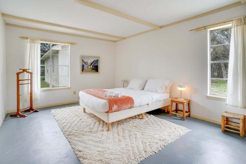 Un dormitorio con una cama grande y dos ventanas. en Frank Lloyd Inspired 3BR - 1'35 Acres & Firepit, en San Marcos