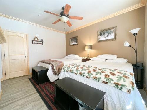 two beds in a hotel room with a ceiling fan at Condo at Cedar Breaks Lodge in Brian Head, UT in Brian Head